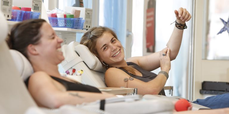 Zwei junge Frau sind glücklich beim Blutspenden