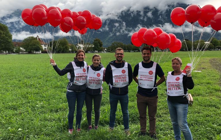 5 junge Menschen stehen draußen und machen auf die Blutstammzellspende aufmerksam.