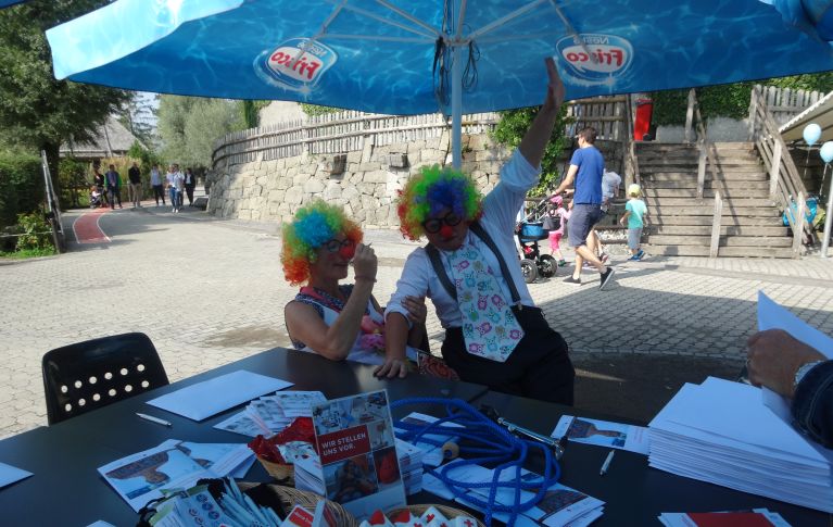 Zwei Clowns winken fröhlich in die Kamera