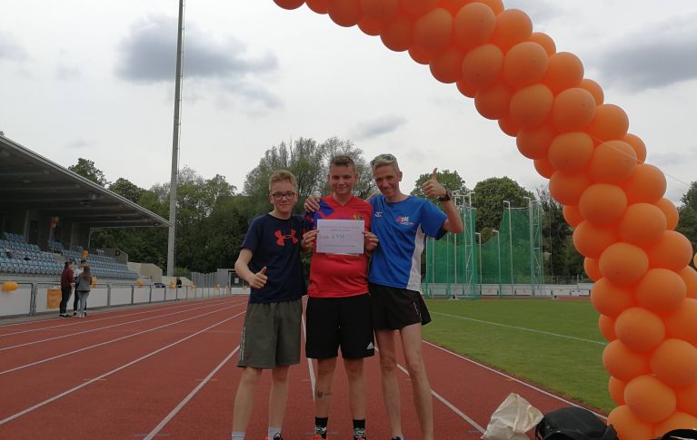 3 fröhliche junge Männer auf der Rennstrecke beim Lauf gegen Leukämie