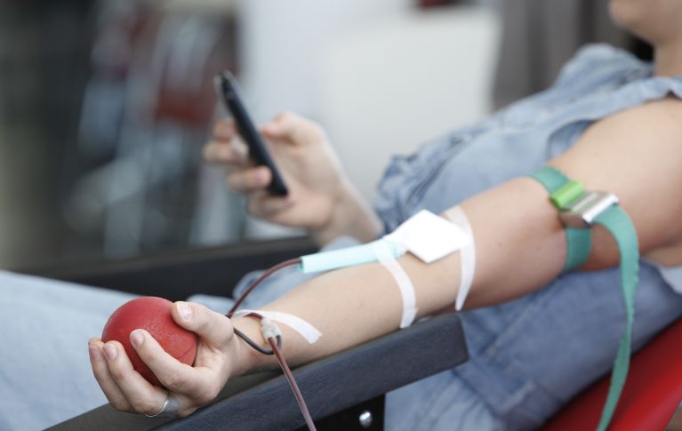 Das Bild zeigt den Arm einer Frau während der Blutspende.